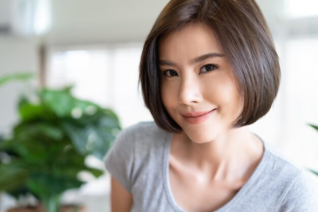 Portrait of happy young Asian girl taking a selfie in living room Natural Beauty and Healthy Woman People sincere emotions lifestyle concept