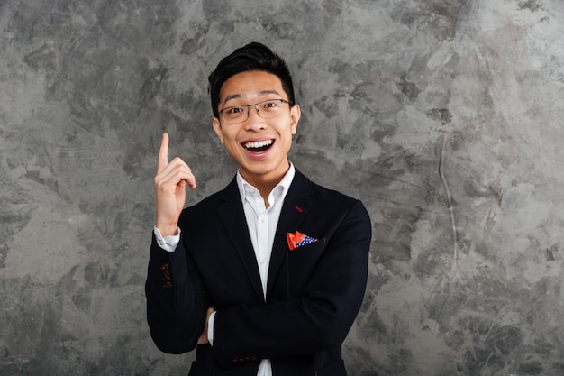 Portrait of a happy young asian man dressed in suit