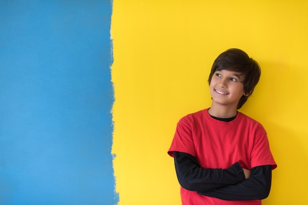 Portrait of a happy young boy in front of colored background