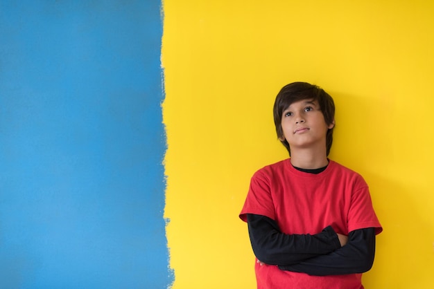 Portrait of a happy young boy in front of colored background