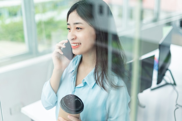 Portrait of happy young business woman talking on the phone