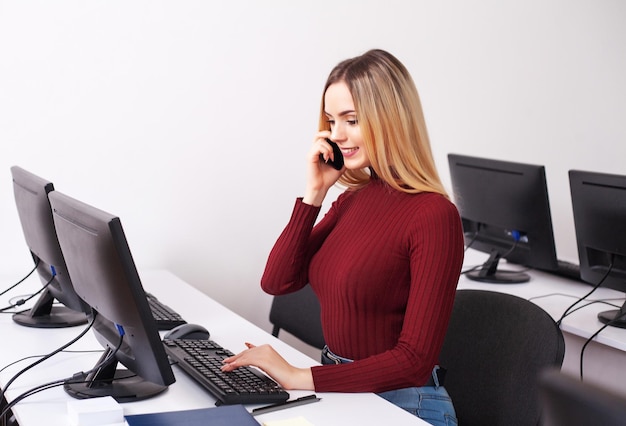 Portrait Of Happy Young Businesswoman Sitting At Desk While Working