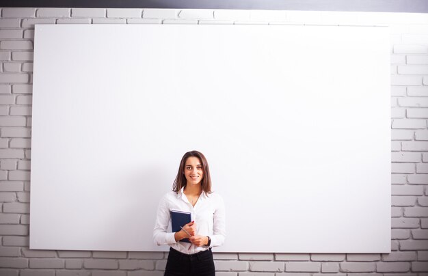 Portrait Of Happy Young Businesswoman woman near on white wall.