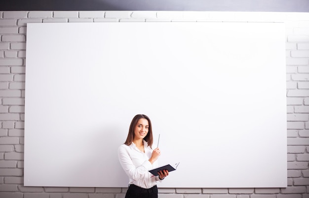 Portrait Of Happy Young Businesswoman woman near on white wall