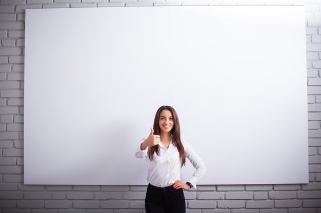 Portrait Of Happy Young Businesswoman woman near on white wall.