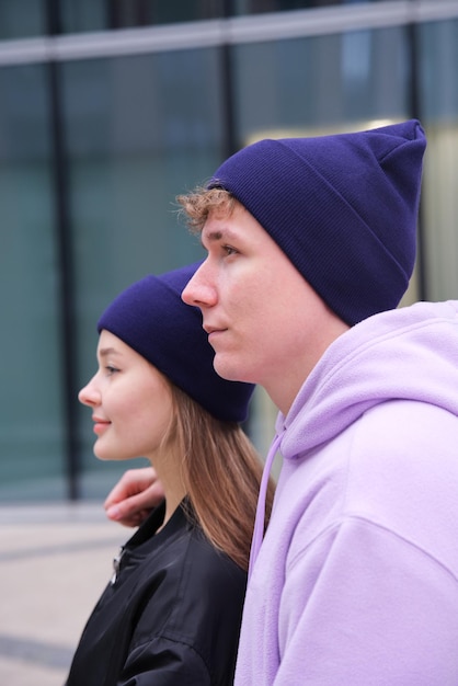 Portrait of happy young couple in hats outdoors posing urban street style clothes