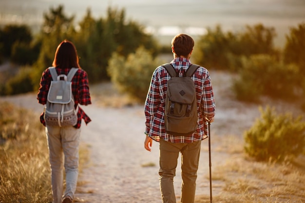 Portrait of happy young couple having fun on their hiking trip Caucasian and asian hiker couple enjoying themselves on summer vacation