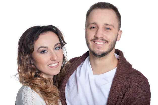 Portrait of happy young couple hugging on white background