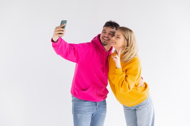 Portrait of a happy young couple showing thumbs up while taking a selfie together