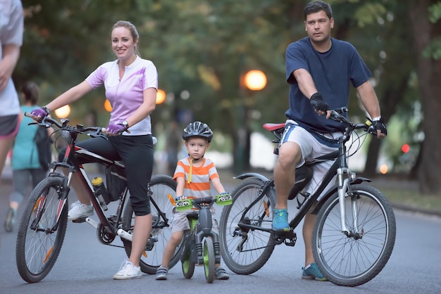 portrait of happy young family with bicycles in park at night