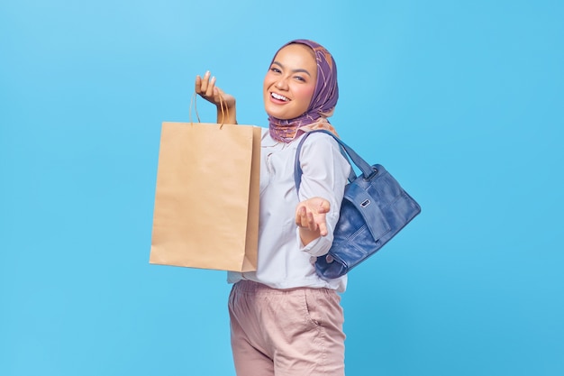 Portrait of happy young girl holding shopping bag