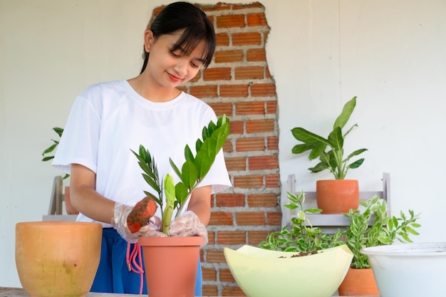 Portrait happy young girl plant a tree in pot at home Asian girl