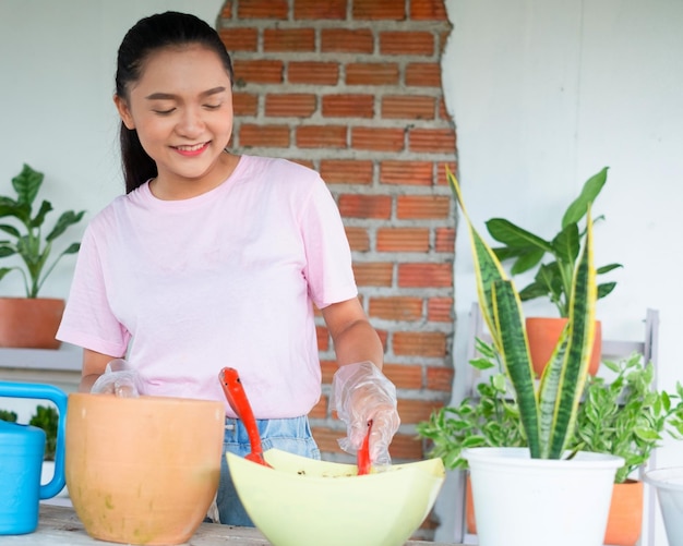 Portrait happy young girl plant a tree in pot at home Asian girl