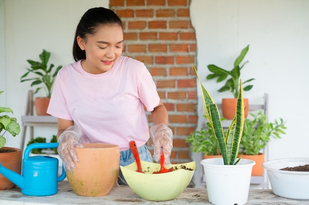 Portrait happy young girl plant a tree in pot at home Asian girl