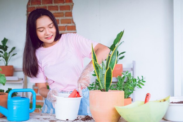 Portrait happy young girl plant a tree in pot at home Asian girl