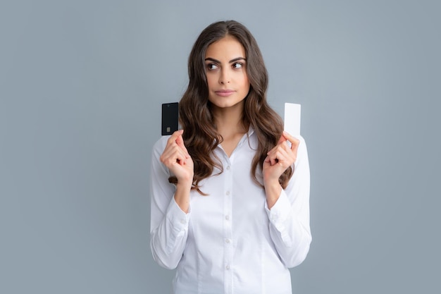 Portrait of a happy young girl showing plastic credit card isolated over grey background Bank card finance and banking concept