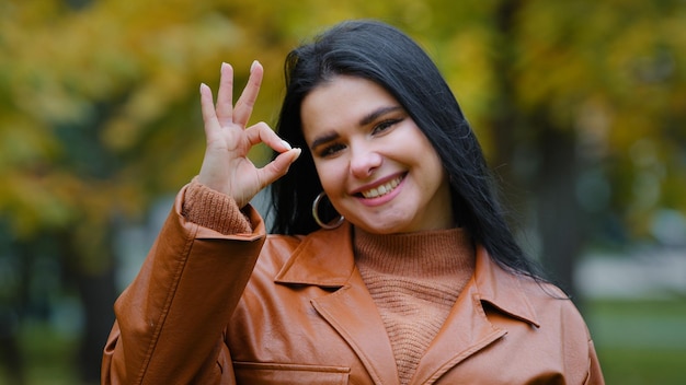 Portrait happy young hispanic woman model standing outdoors posing smiling white toothy dental smile