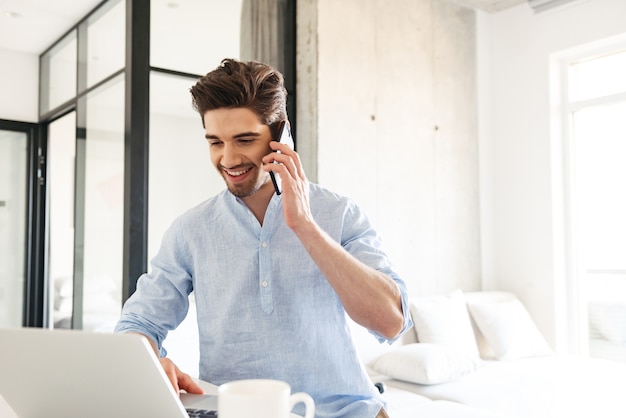 Portrait of a happy young man using laptop computer