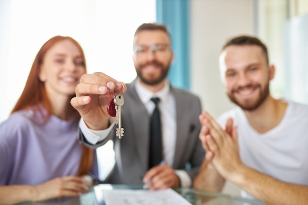 Portrait of happy young newly married family with real estate agent