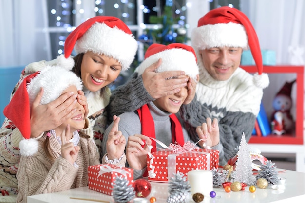 Portrait of happy young parents and children with Christmas gifts