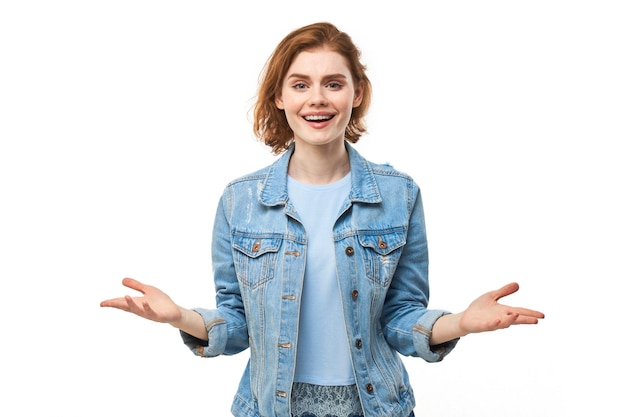 Portrait of happy young redhead woman spreading hands with joy and inspiration Hands wide open isolated on white studio background