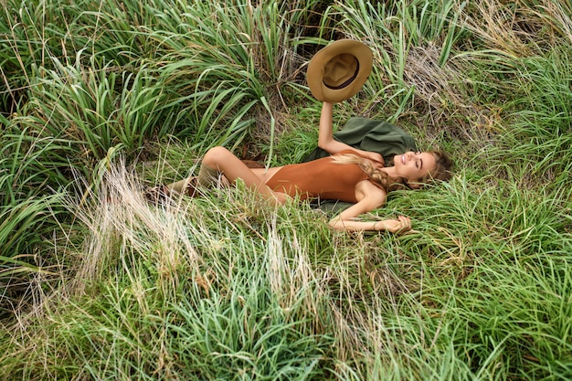 Portrait of happy young woman with backpack exploring wild steppe