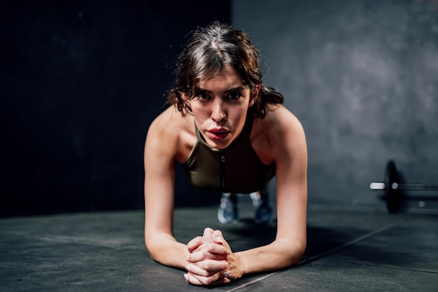 Portrait healthy woman yoga plank during workout at fitness gym. Health and wellbeing lifestyle.