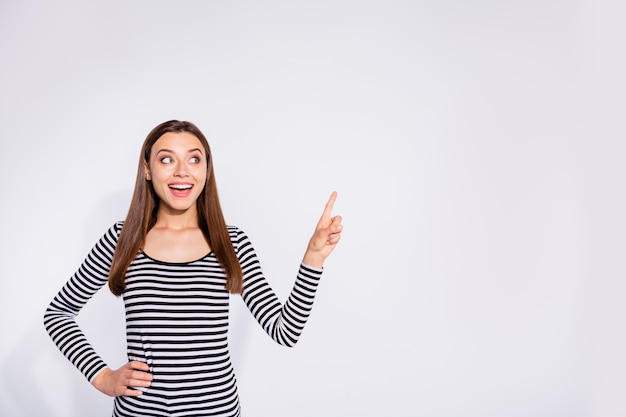 Portrait of her she nice attractive charming lovely cheerful cheery wondered girlish straight-haired girl pointing forefinger copy space ad advert isolated over white light wall