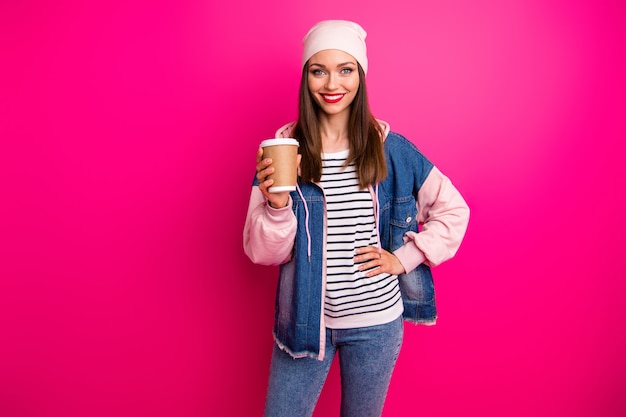 Portrait of her she nice attractive lovely pretty cheerful cheery girl wearing street style holding in hands coffee paper cup isolated over bright vivid shine vibrant pink fuchsia color