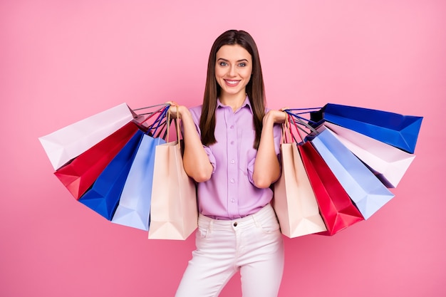 Portrait of her she nice attractive lovely pretty fashionable cheerful cheery long-haired girl holding in hands buyings spending money isolated on pink pastel color background