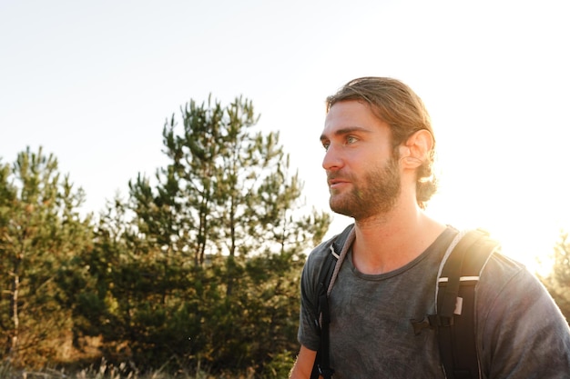 Photo portrait of hiker man with backpack trekking in the mountains