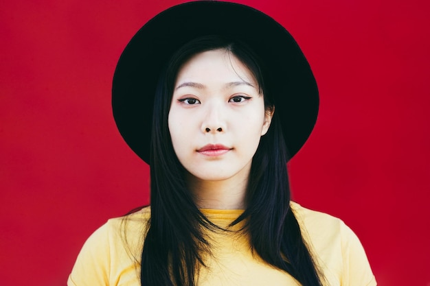 Portrait of hipster asian girl looking at camera outdoor - Focus on face