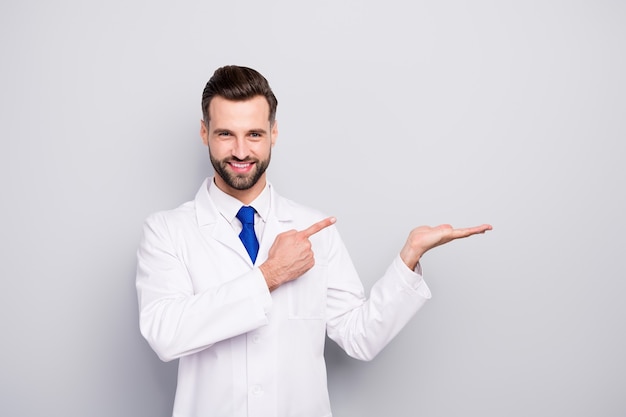 Portrait of his he nice attractive cheerful cheery confident doc holding on palm showing copy space new solution alternative isolated on light white gray pastel color