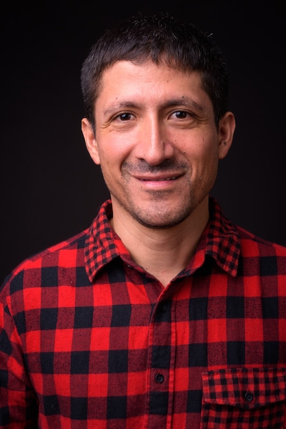 Portrait of Hispanic man against black background