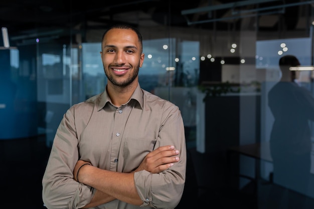 Portrait of hispanic successful businessman successful man in shirt looking at camera with crossed