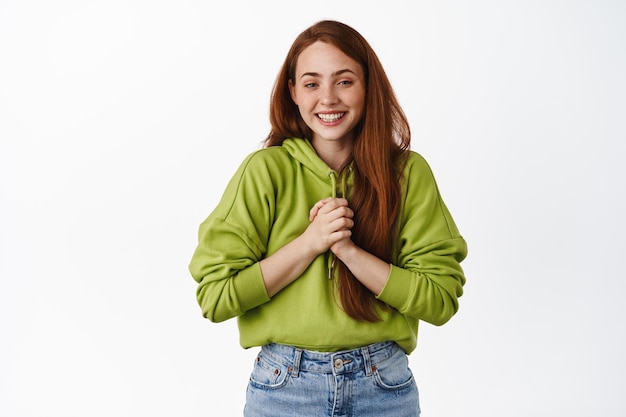 Portrait of hopeful redhead girl expect something, being touched and flattered, feeling grateful, say thank you, standing over white background.