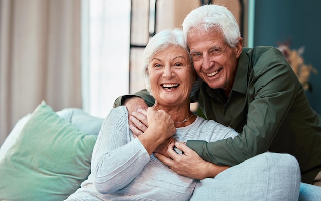 Portrait hug and senior couple in living room in home smiling and bonding Love retirement and smile of happy elderly man and woman on sofa embrace and enjoying quality time together in house