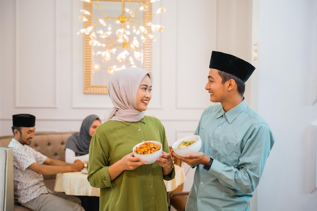 Portrait of husband and wife serving food for friend and family for break fasting together during ra