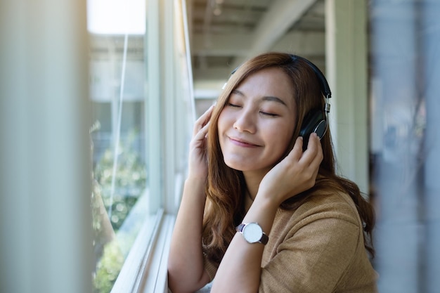 Portrait image of a beautiful young asian woman enjoy listening to music with headphone