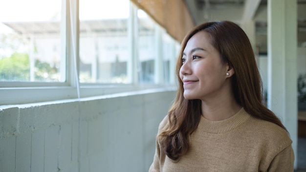 Portrait image of a beautiful young asian woman sitting in cafe with feeling happy