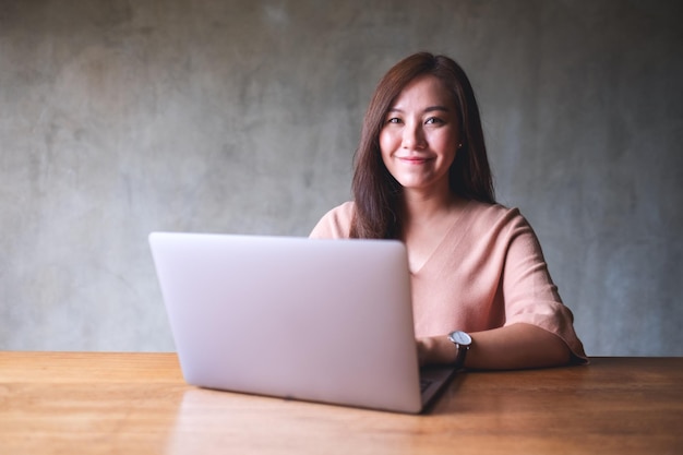 Portrait image of a beautiful young woman using and working on laptop computer