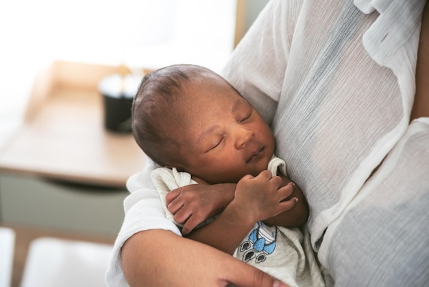 Portrait images of an African 12dayold baby newborn son sleeping with his mother being held