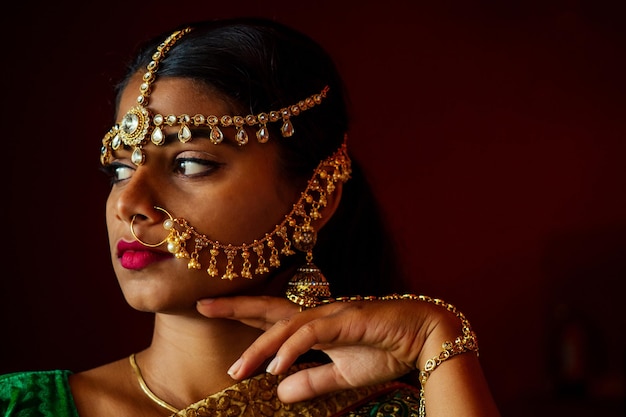 Portrait indian beautiful female in golden rich jewelery and tradition saree face closeup professional makeup wearing bindi on head Muslim Woman face portrait with bindis maang tikka nathnose Pin