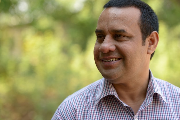 Portrait of Indian businessman with short hair relaxing at the park outdoors