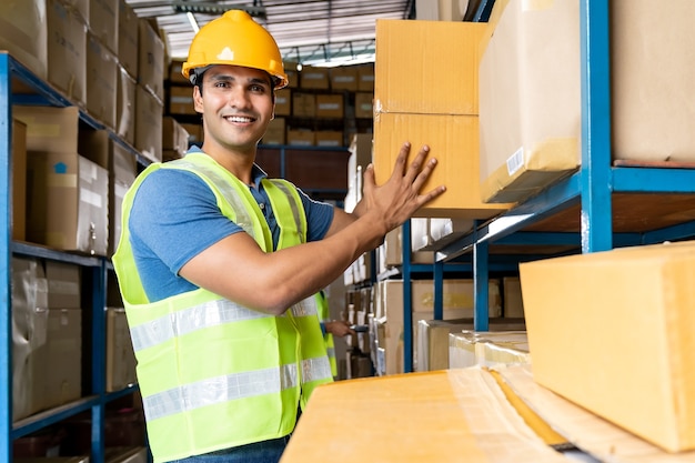 Portrait of Indian warehouse worker hold cardboard box