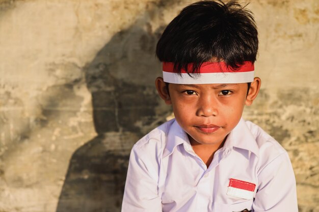 Portrait of Indonesian elementary school student wearing red white attribute to celebrate independen