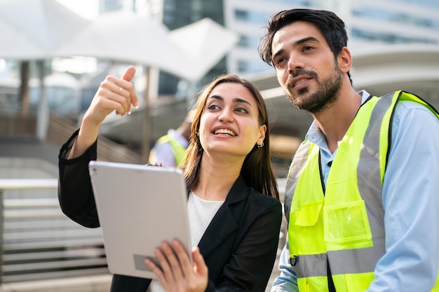 Portrait of an industrial man and woman engineer with tablet in a factory, talking.