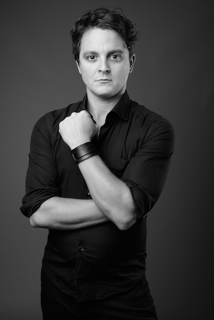 Portrait of Italian businessman wearing black shirt on gray in black and white