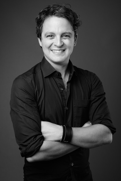 Portrait of Italian businessman wearing black shirt on gray in black and white