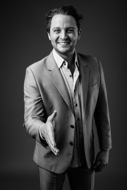 Portrait of Italian businessman wearing suit on gray in black and white